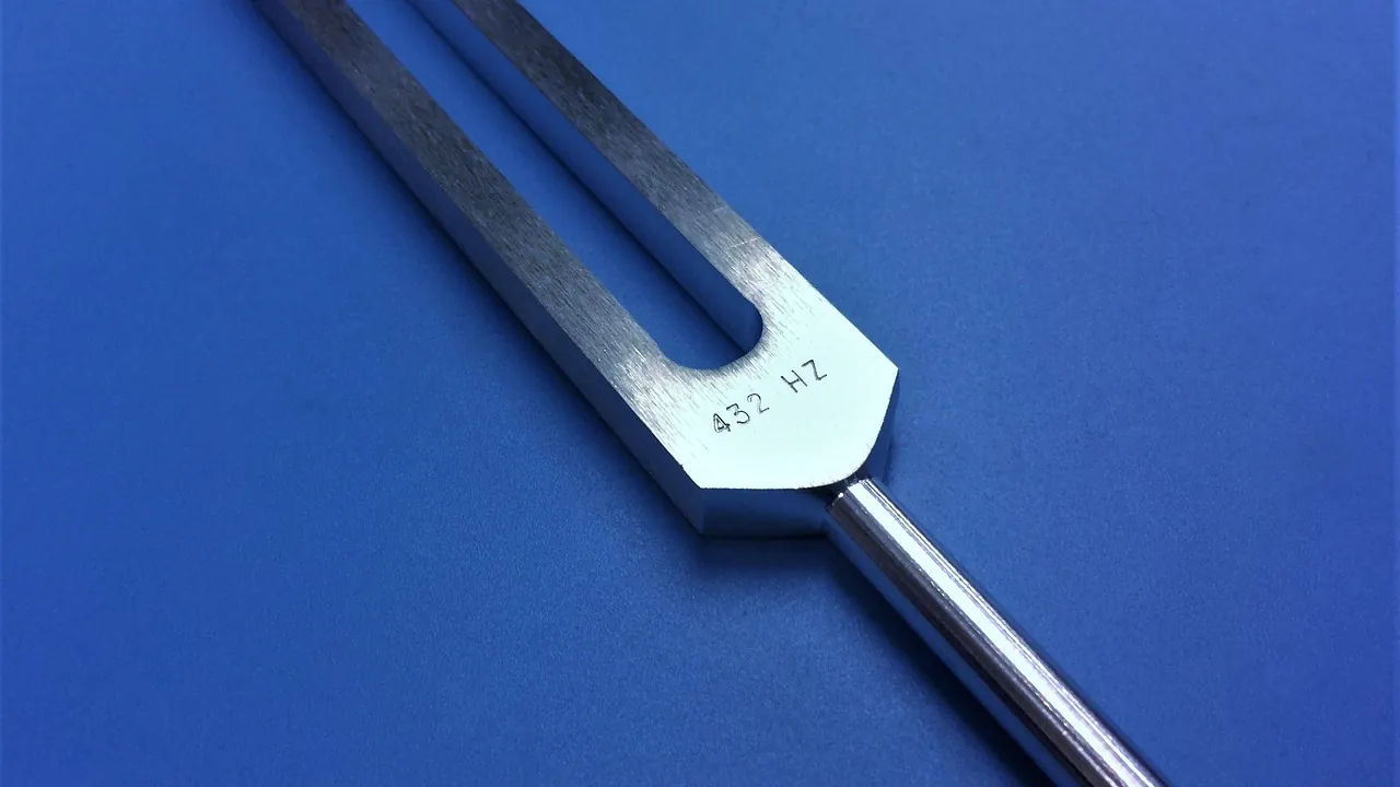 Diapason posé sur un fond bleu, sa fréquence gravée